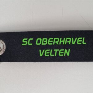 Schwarzer Filz-Schlüsselanhänger mit Metallring und grünem Schriftzug SC Oberhavel Velten.